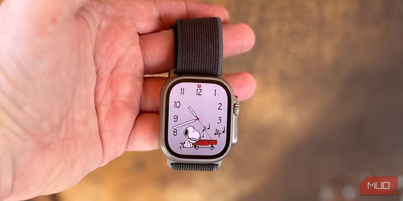Apple Watch Ultra 2 in a man's hand showing a cartoon watch face