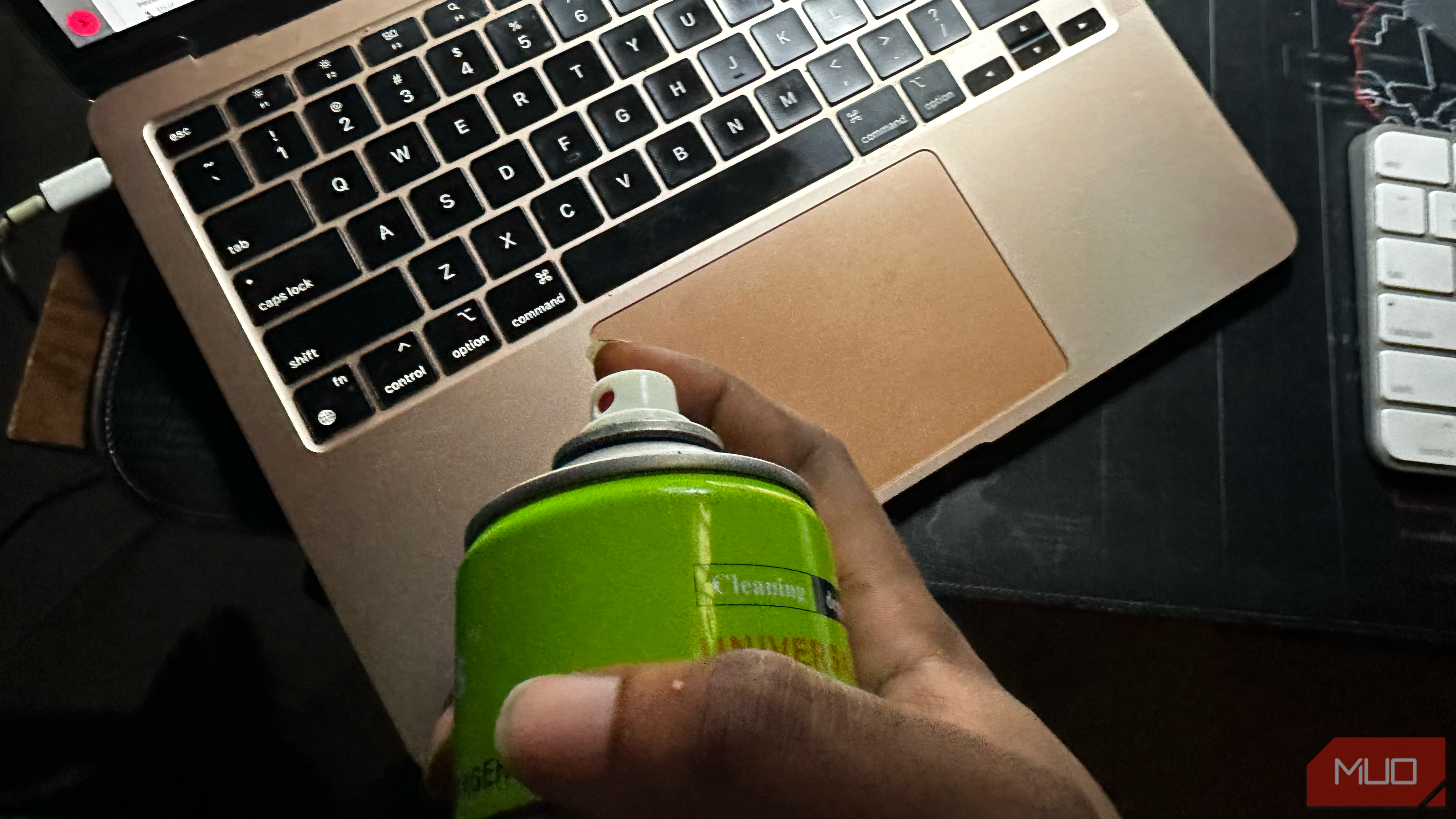 Aerosol spray hovering over a MacBook