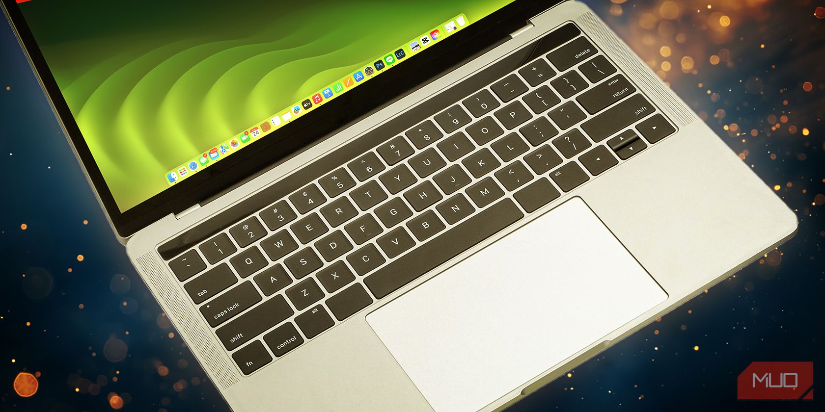 A laptop with an illuminated keyboard is set against a sparkling golden background, suggesting creativity or inspiration.