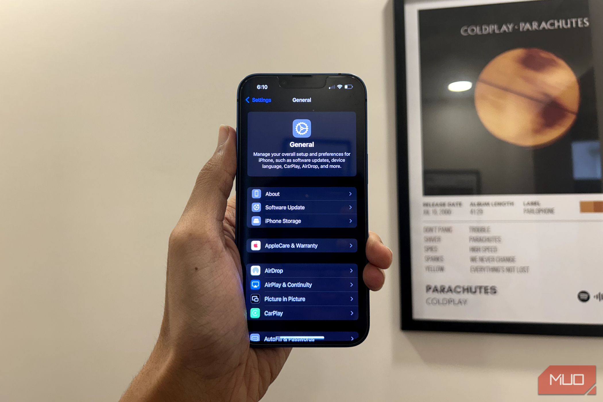 A man holding an iPhone showing the redesigned Settings app in iOS 18