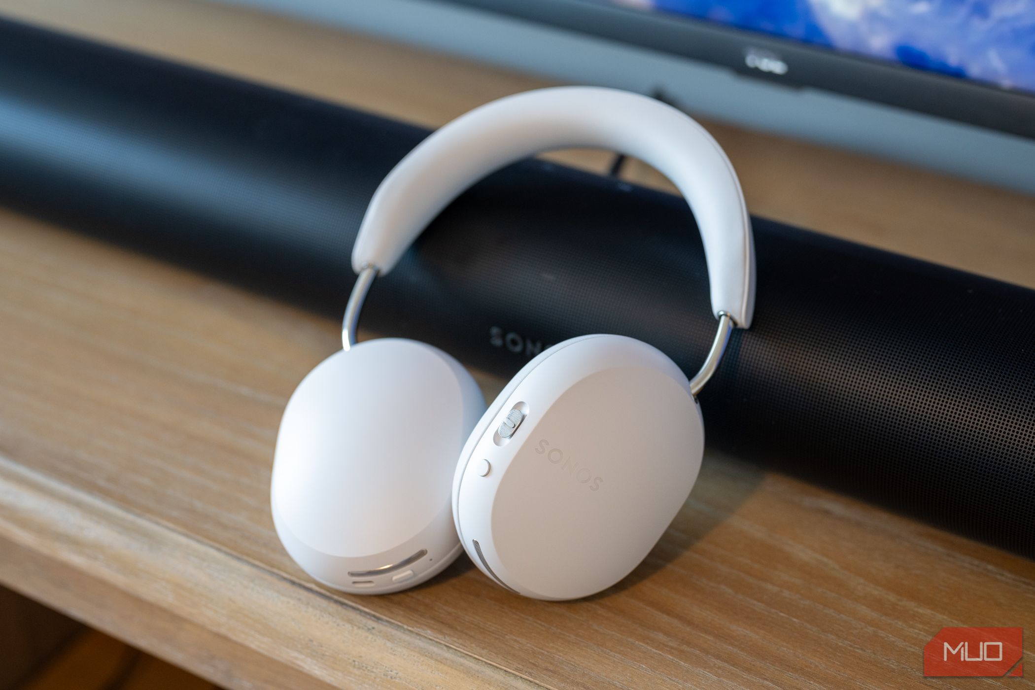 Sonos Ace headphones resting against the Arc soundbar