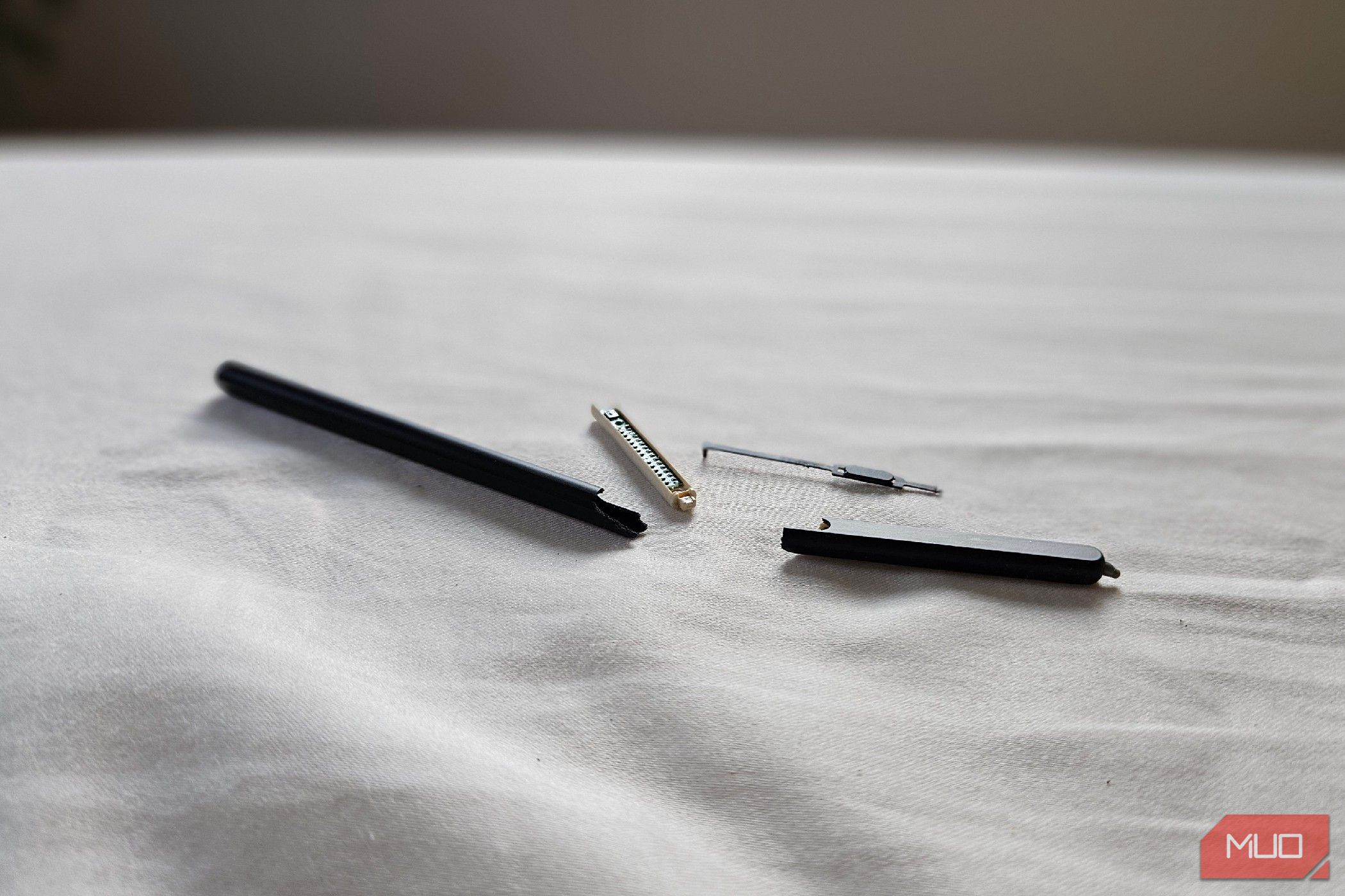 A broken S Pen Fold Edition on a bed.