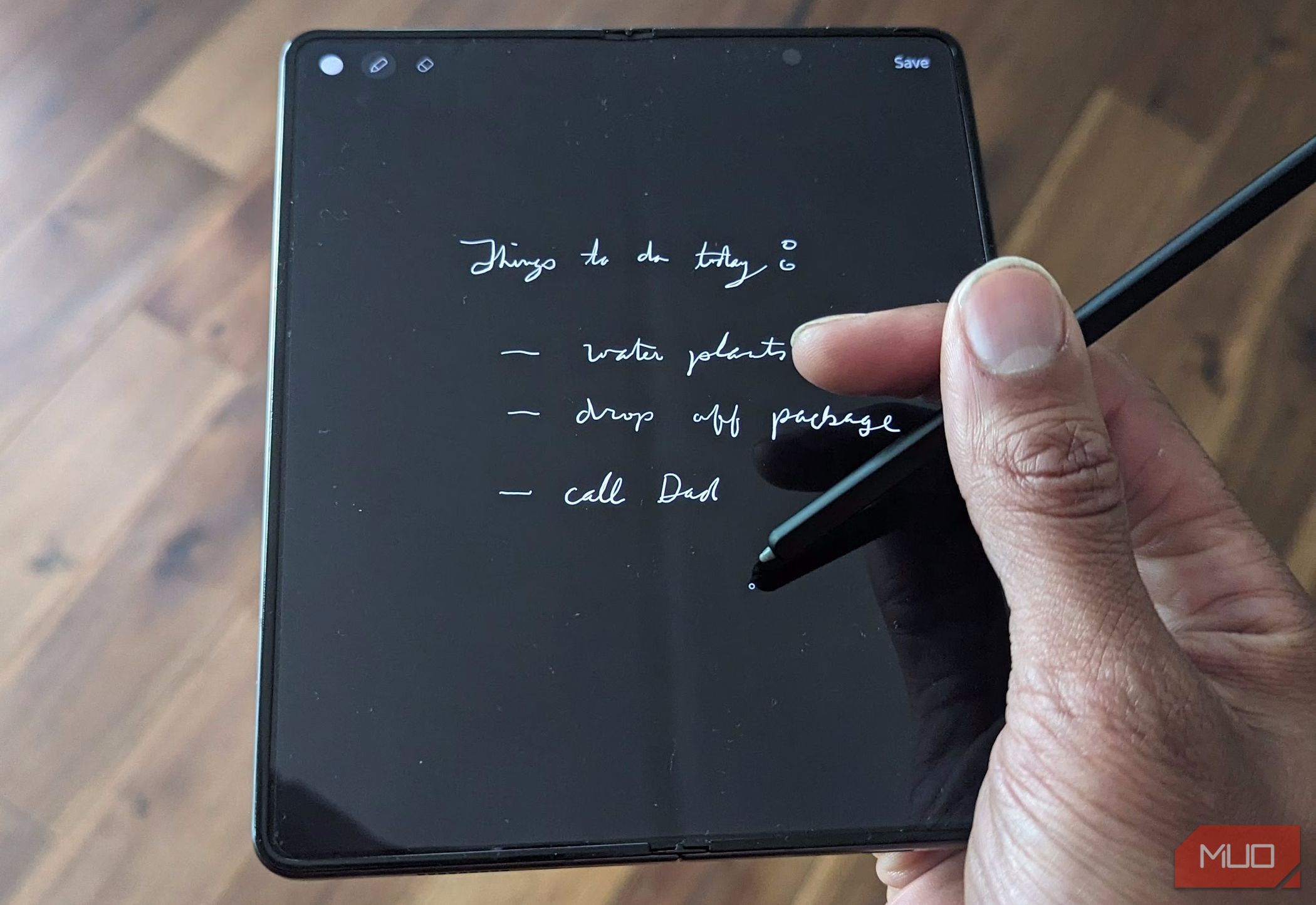 A man holds a Samsung Galaxy Z Fold with an S Pen displaying the Samsung Notes app