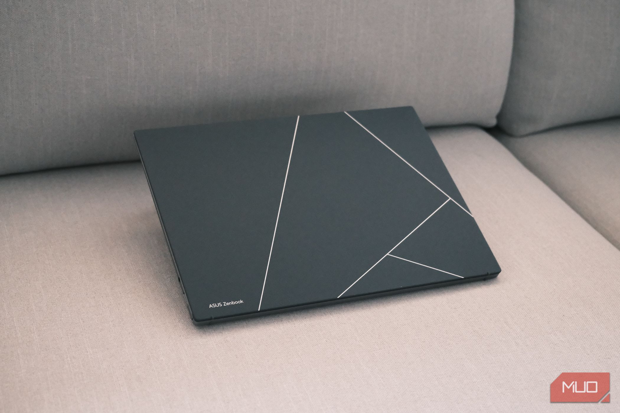 Tampa OLED do ASUS Zenbook S 13 em um sofá (angulado)