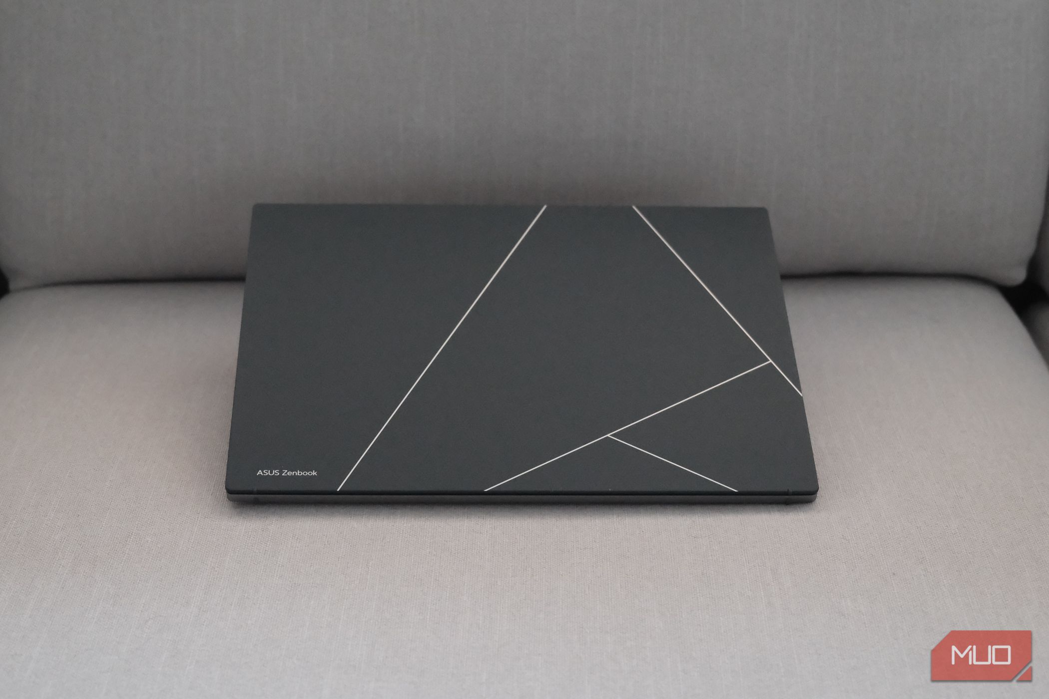 Tampa OLED do ASUS Zenbook S 13 em um sofá (em frente)