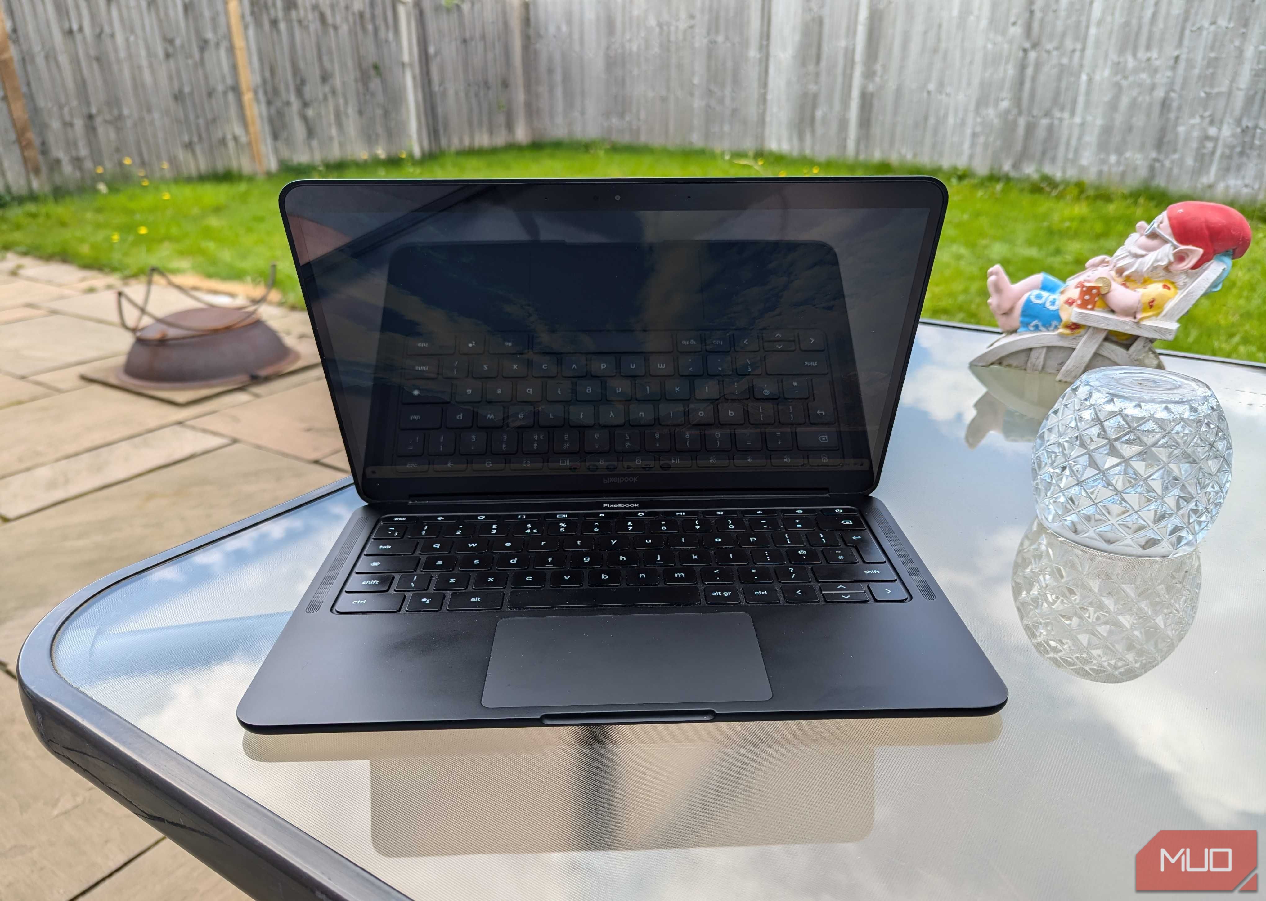 An open Chromebook on a garden table