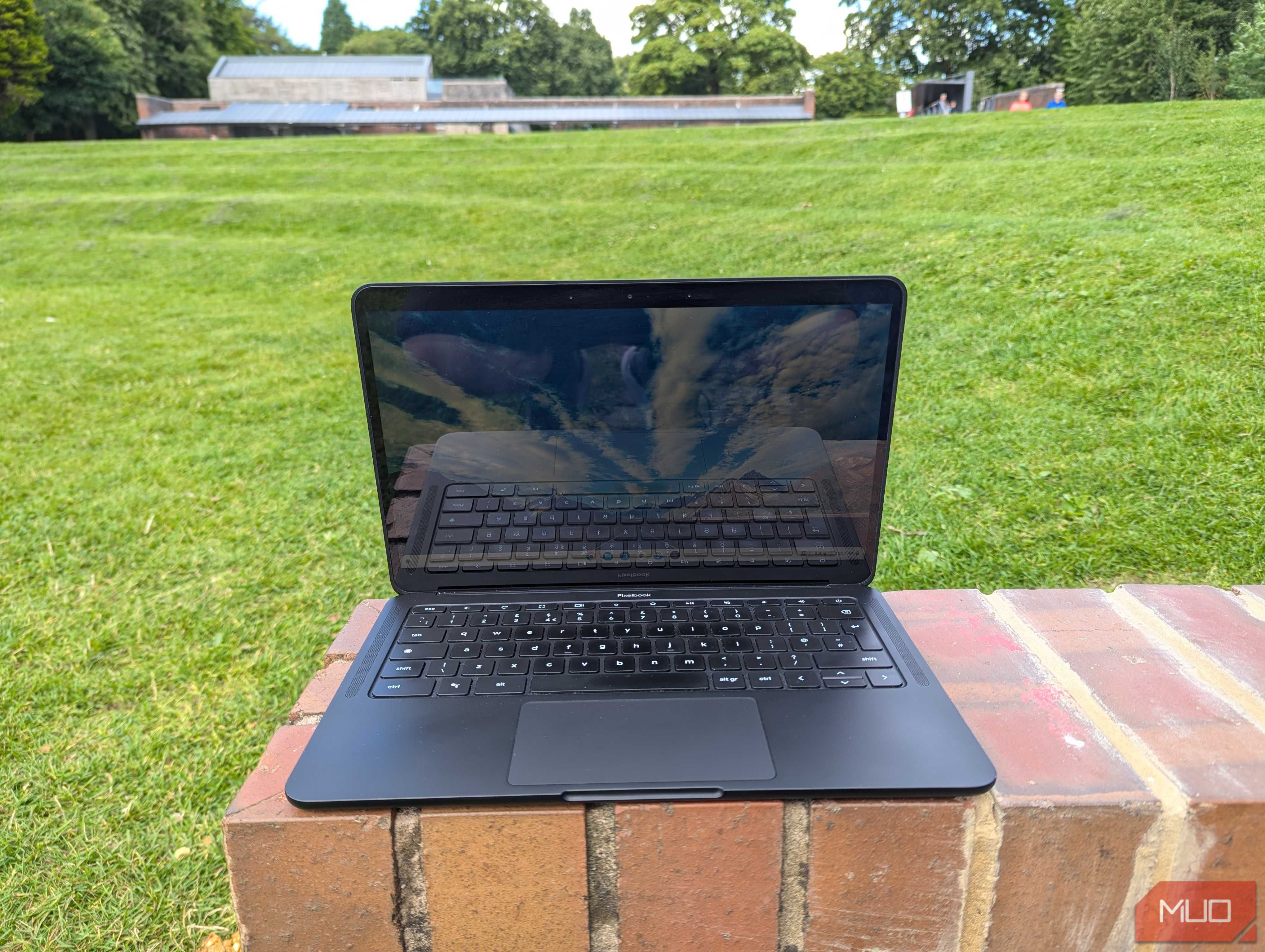 A Chromebook open on a brick wall in the park