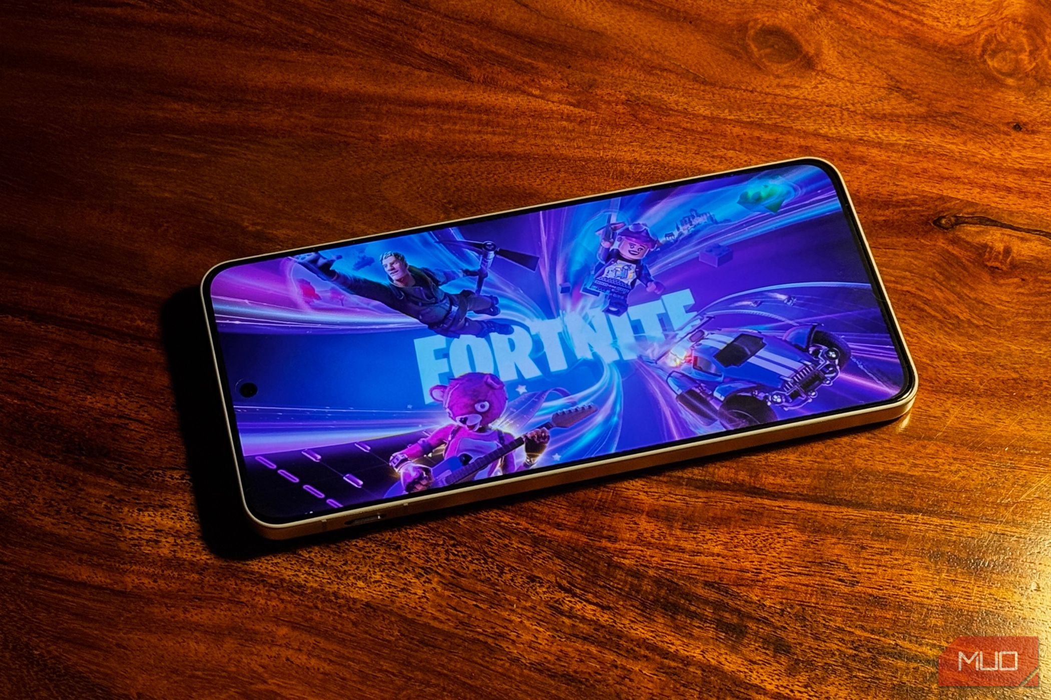 phone placed on a wooden surface with fortnite splashscreen visible