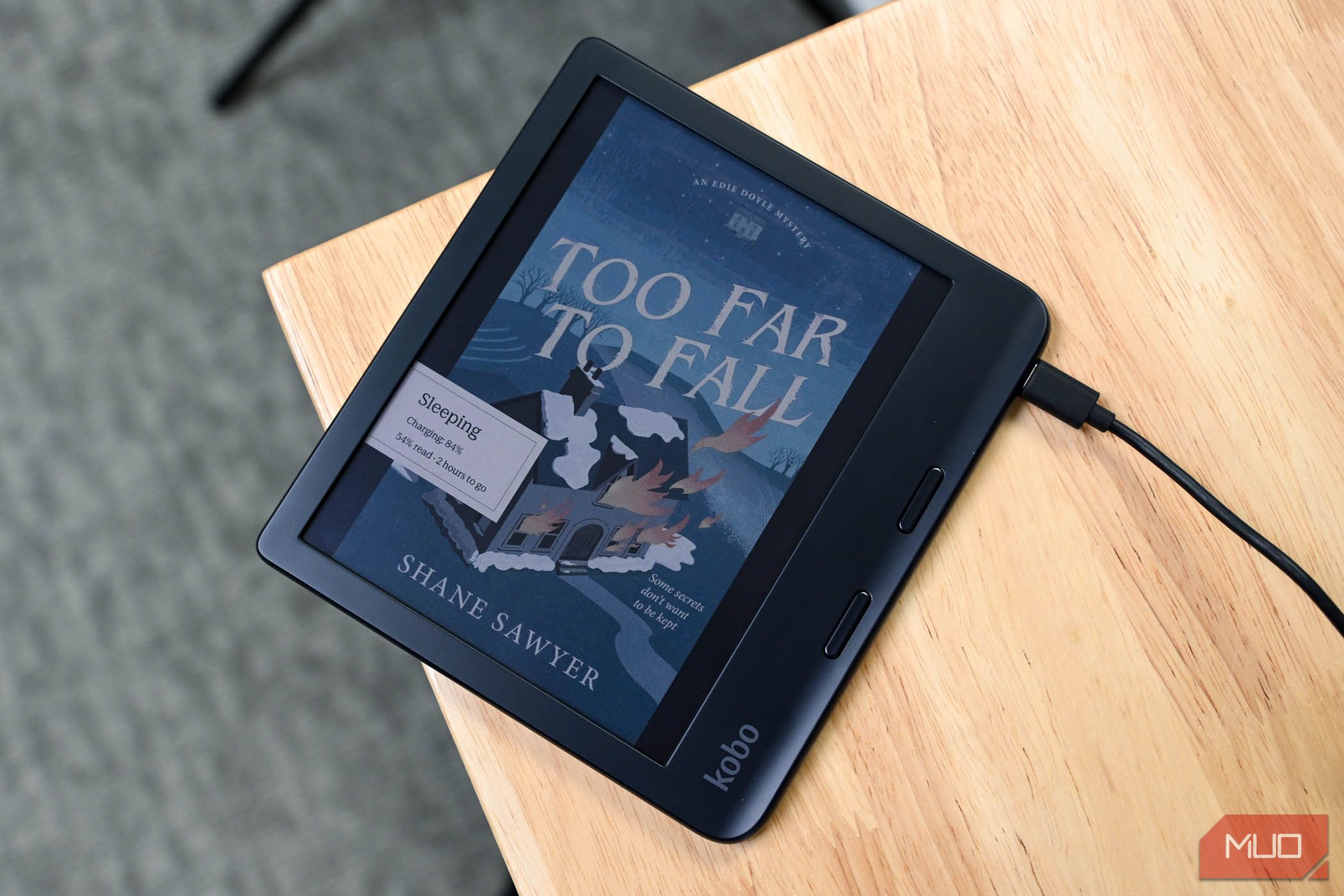 Charging the Kobo Libra Colour with the sleep screen on a book on desk