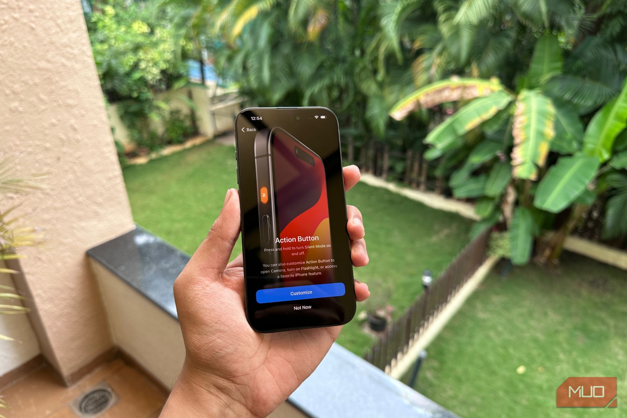 iPhone 15 Pro Held by a man showing the action button feature splash screen