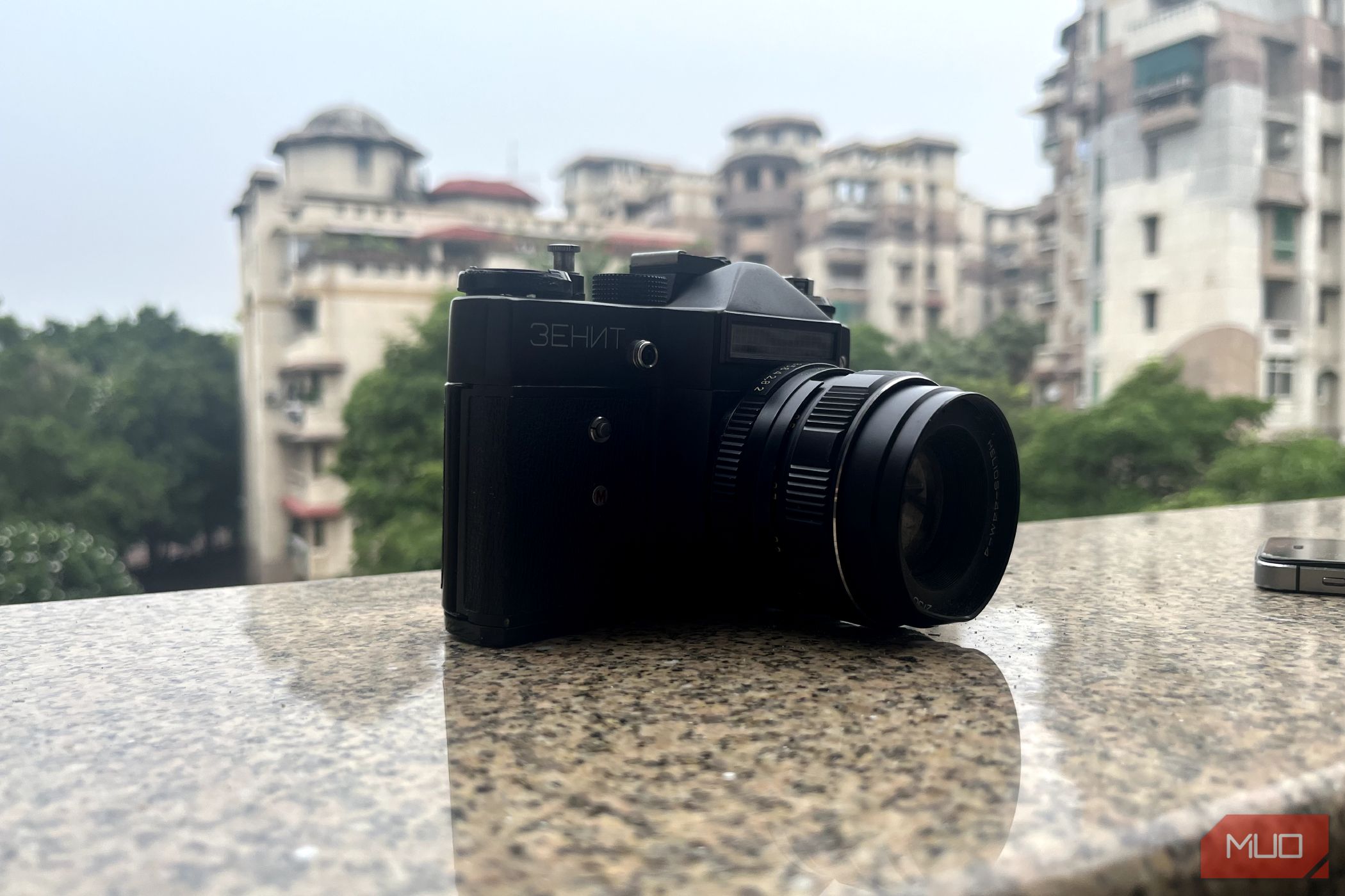 A photo of a retro film camera on a balcony ledge clicked using an iPhone 14.