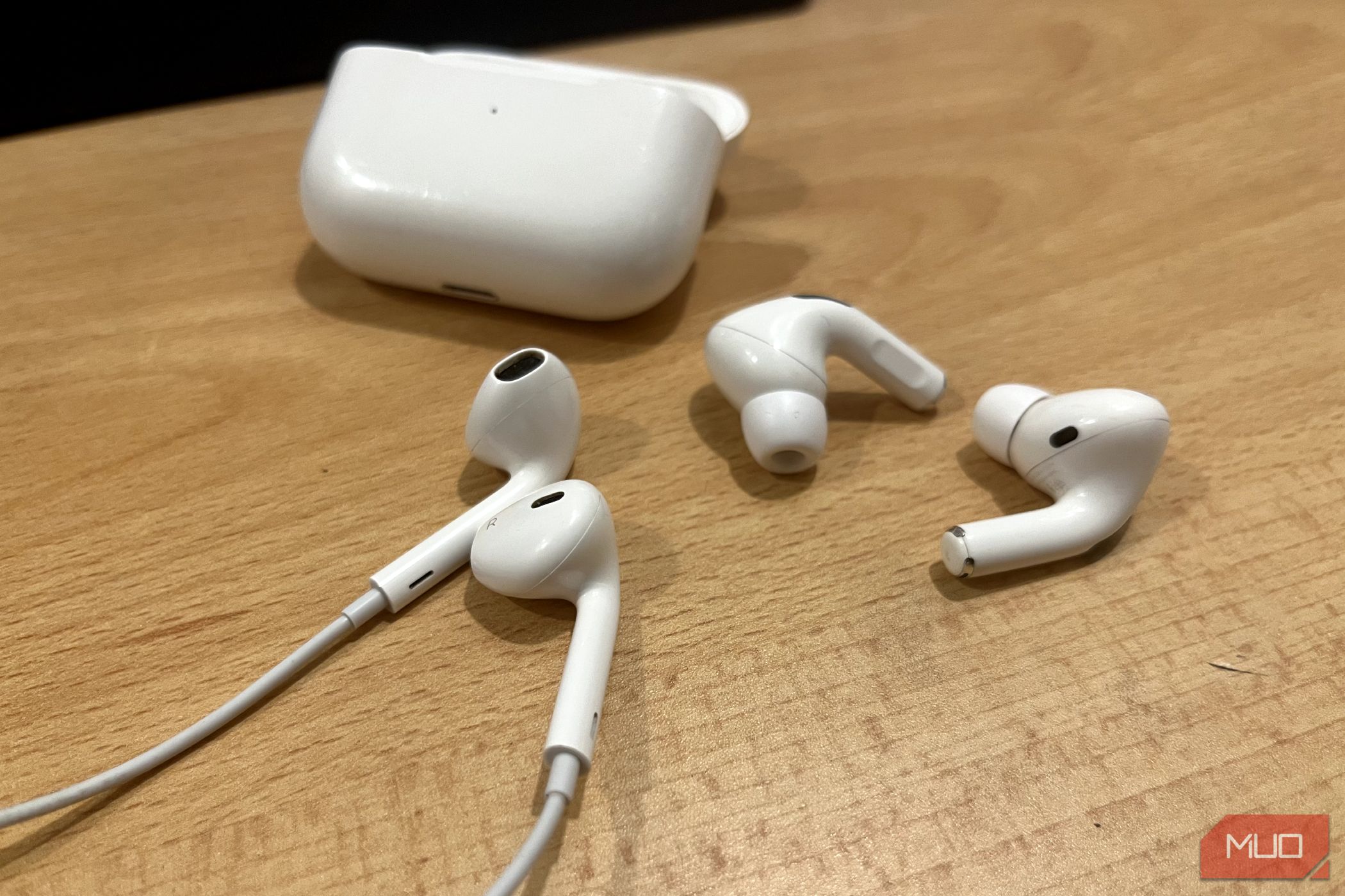 EarPods and AirPods Pro, along with its case, resting on a table.