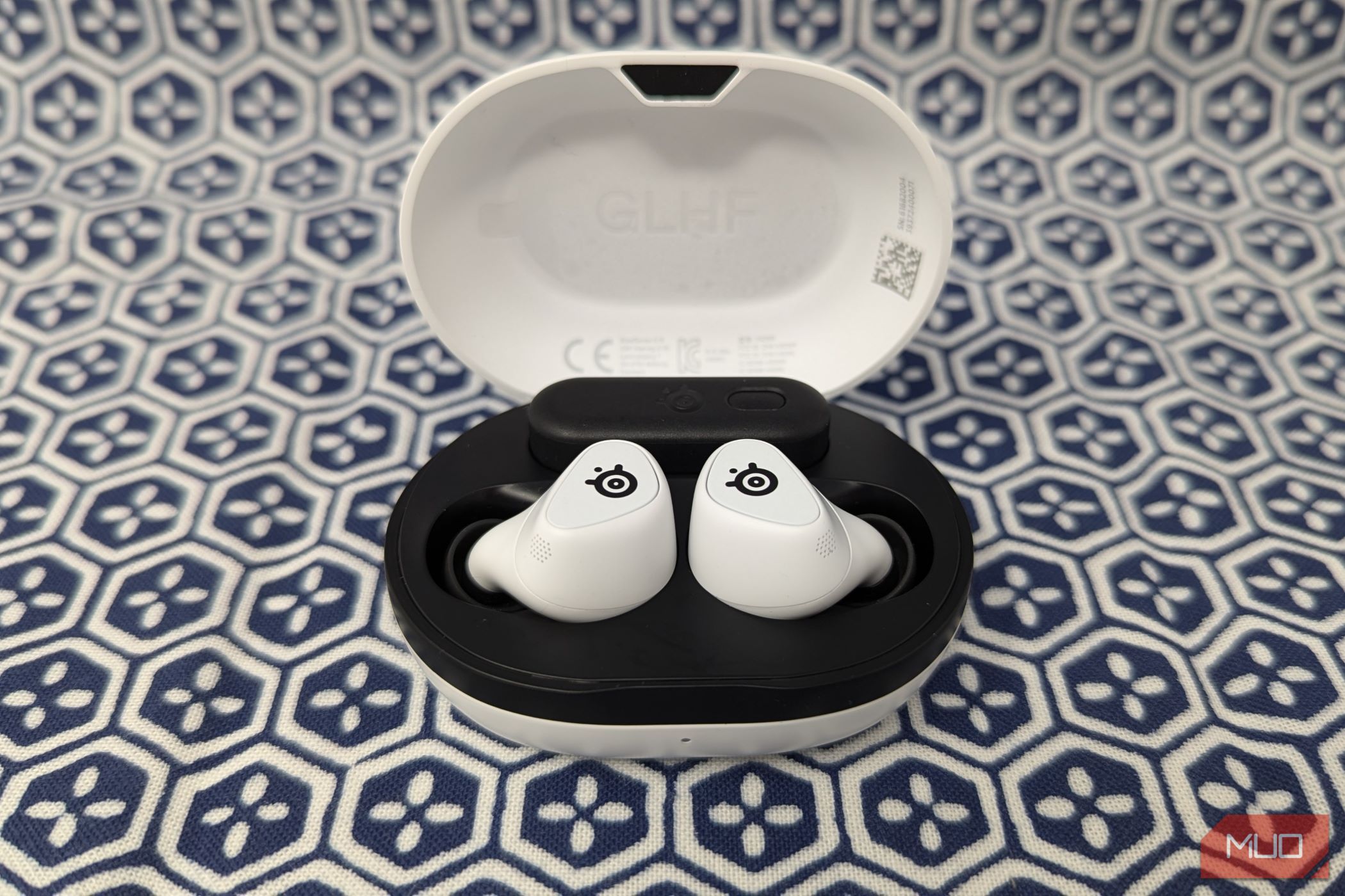 White wireless earbuds in a white case on a blue and white background