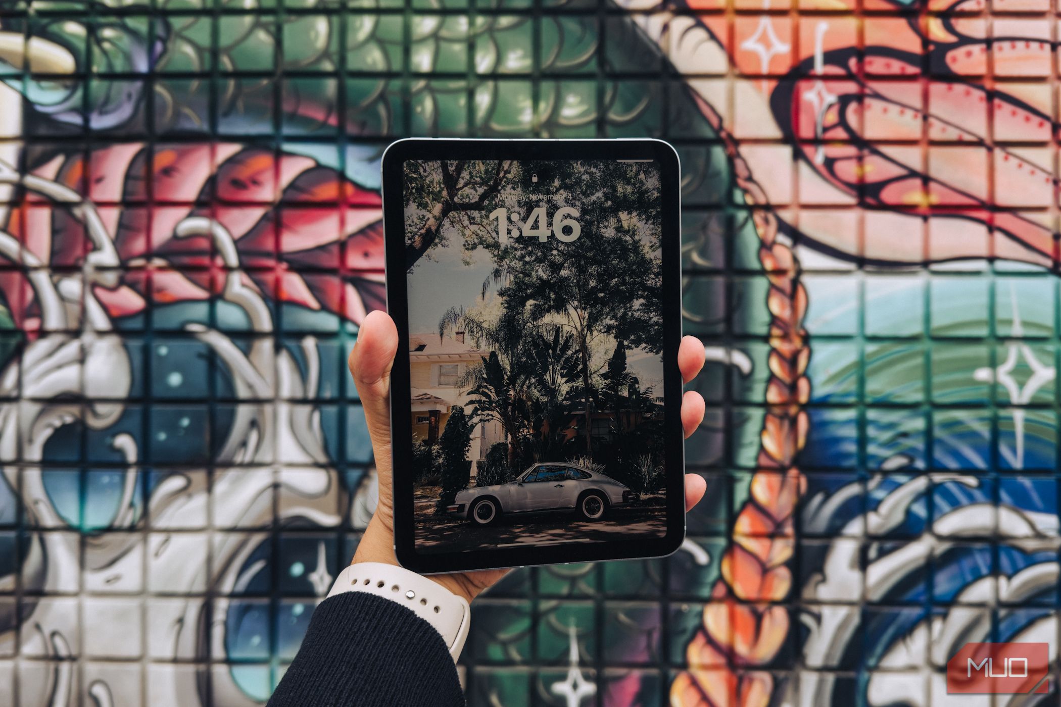 iPad mini (A17 Pro) in hand against a graffiti background (screen side)