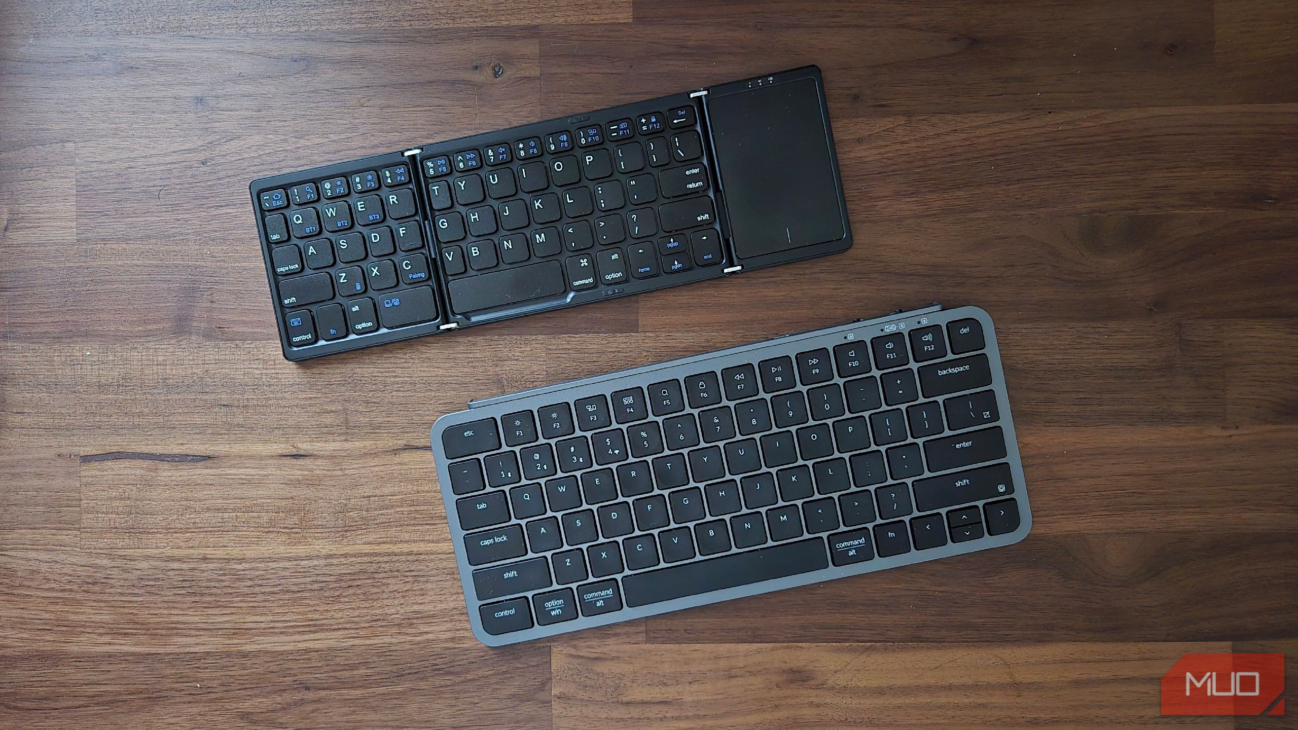 A foldable Bluetooth keyboard next to a non-foldable one.