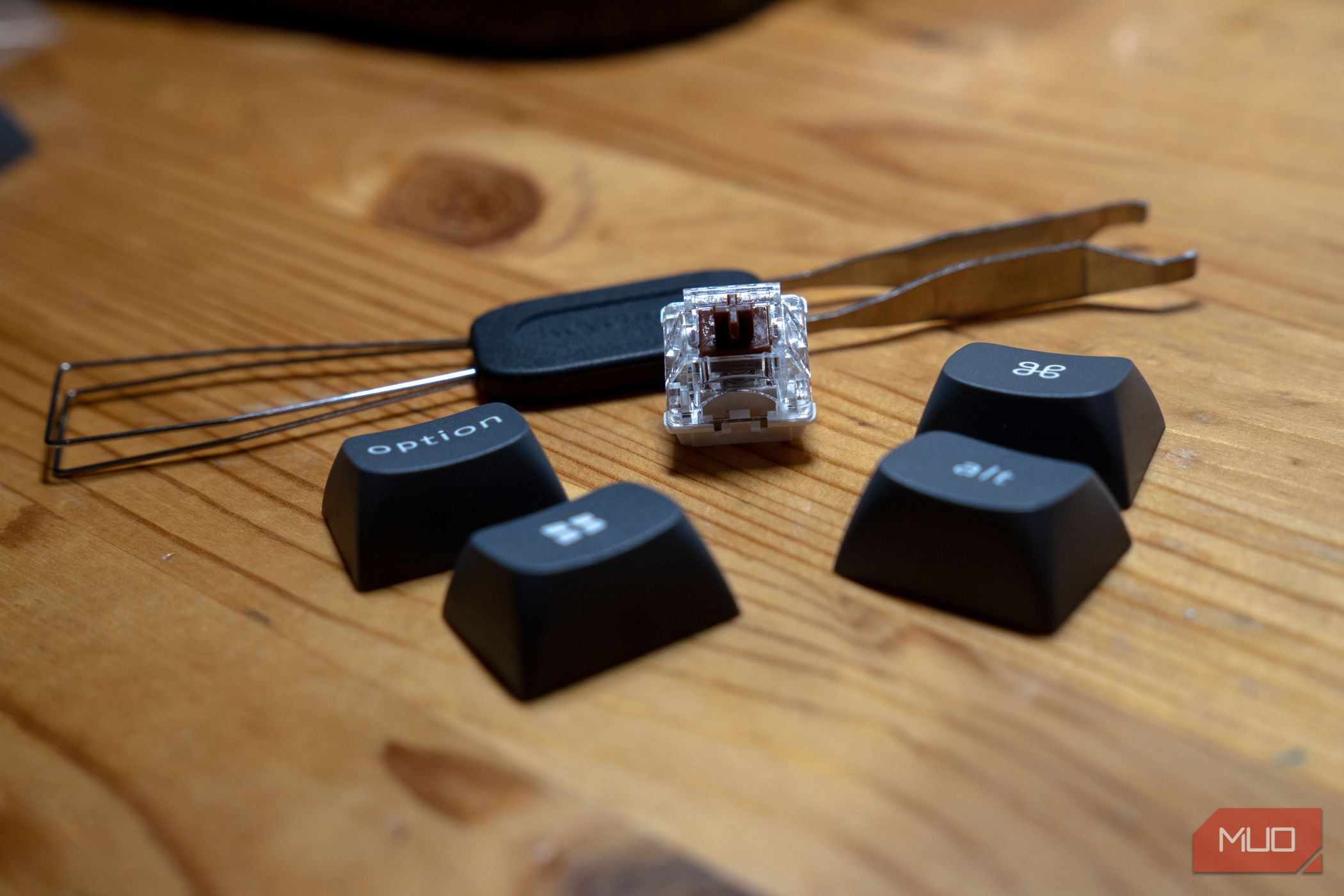 Keychron K8 Max cap and switch remover tool with caps and a switch.