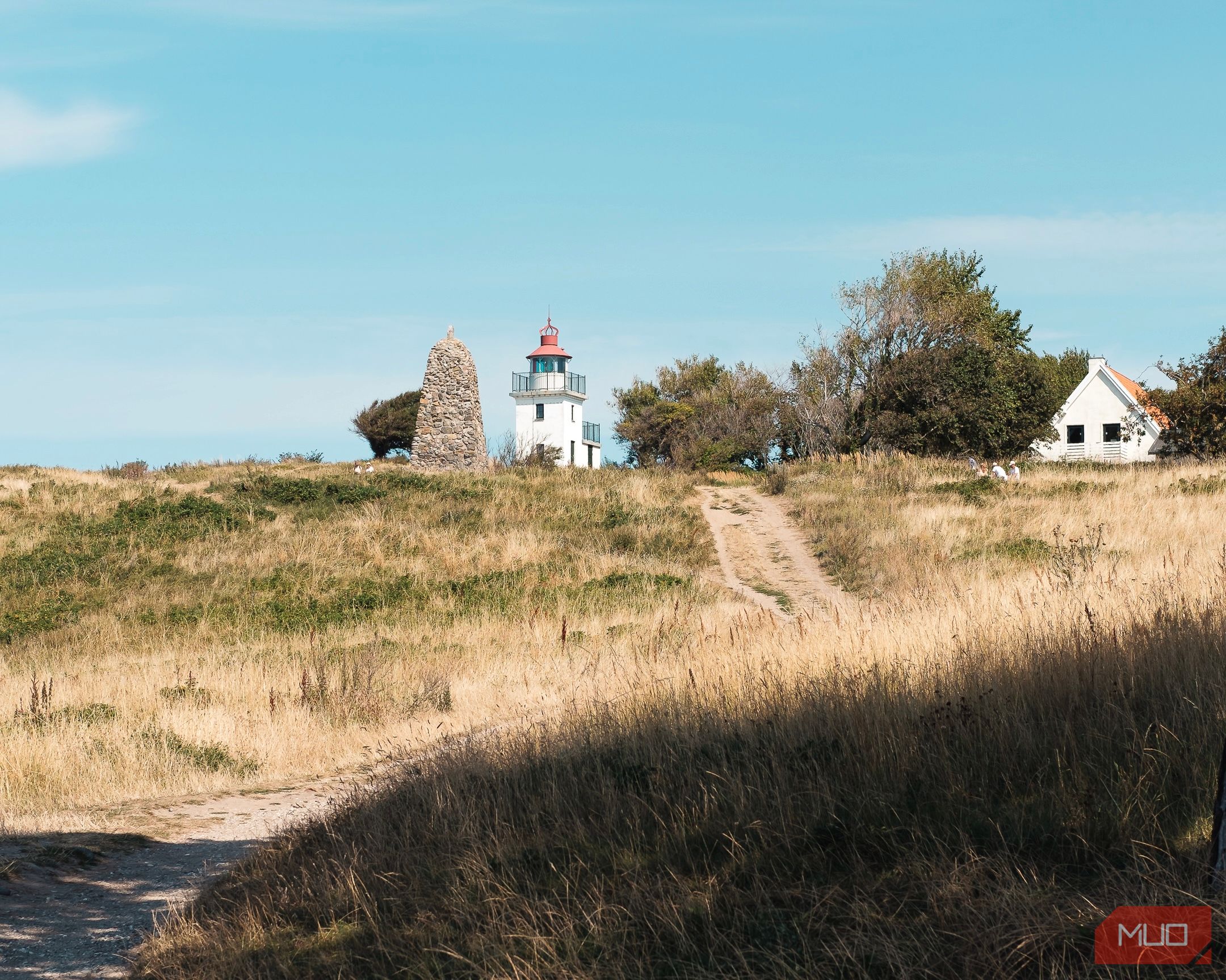 An image of a summerhouse and lighthouse during the summer