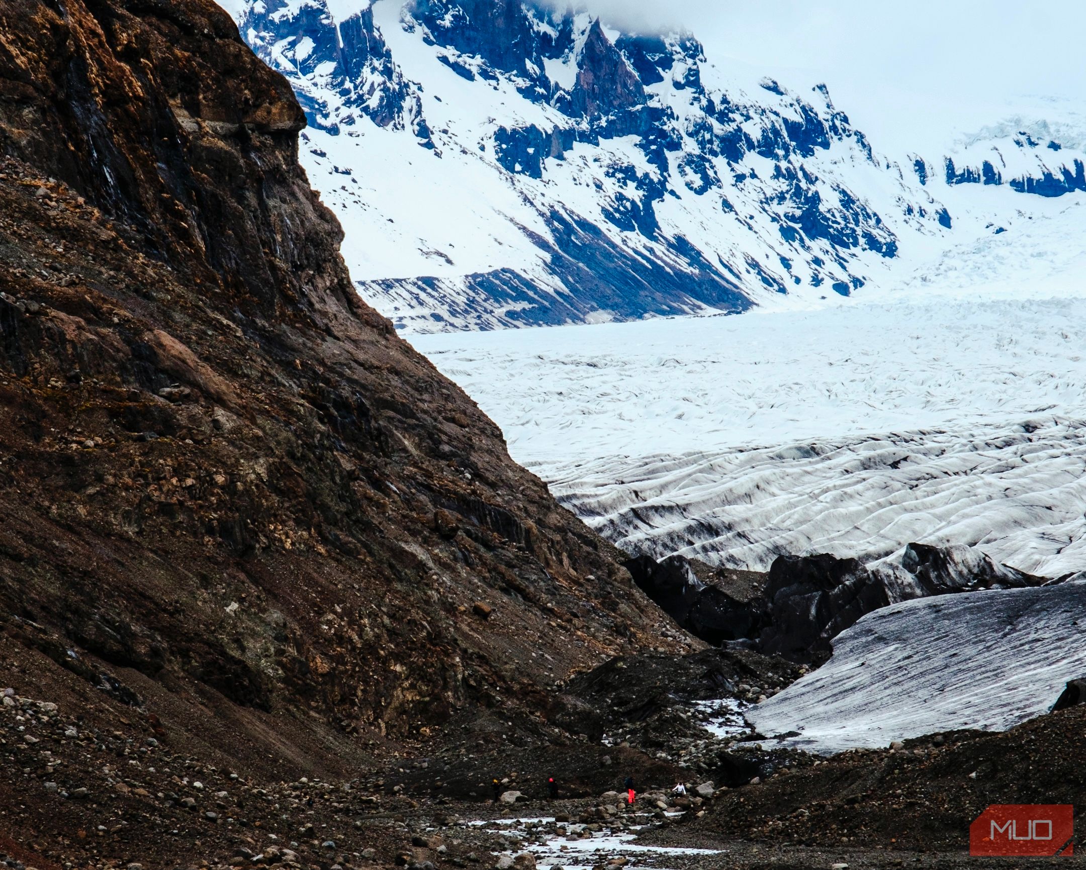 A photo of a person hiking among a glacier and mountain in a national park