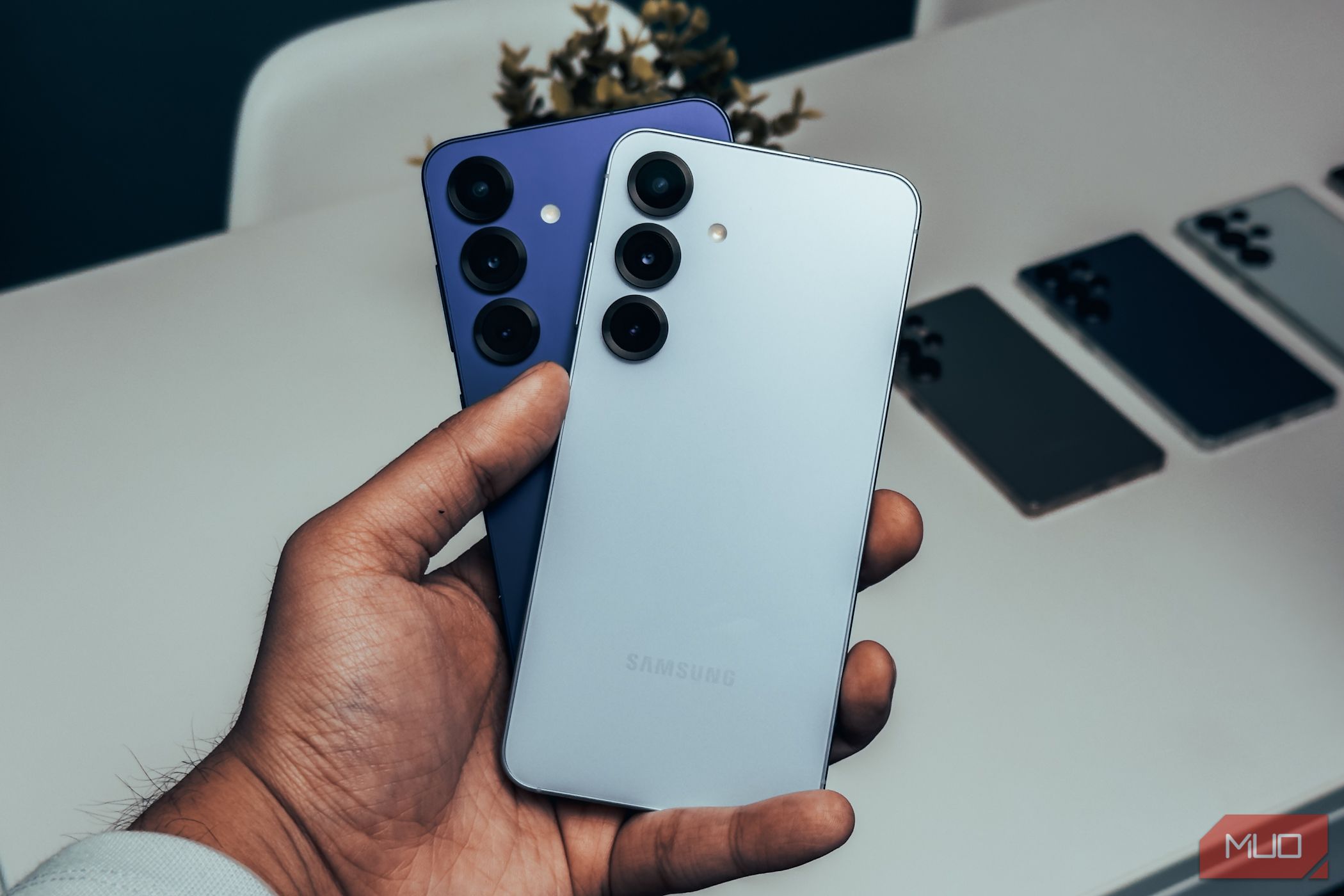 Samsung Galaxy S25 in White and Navy in hand.