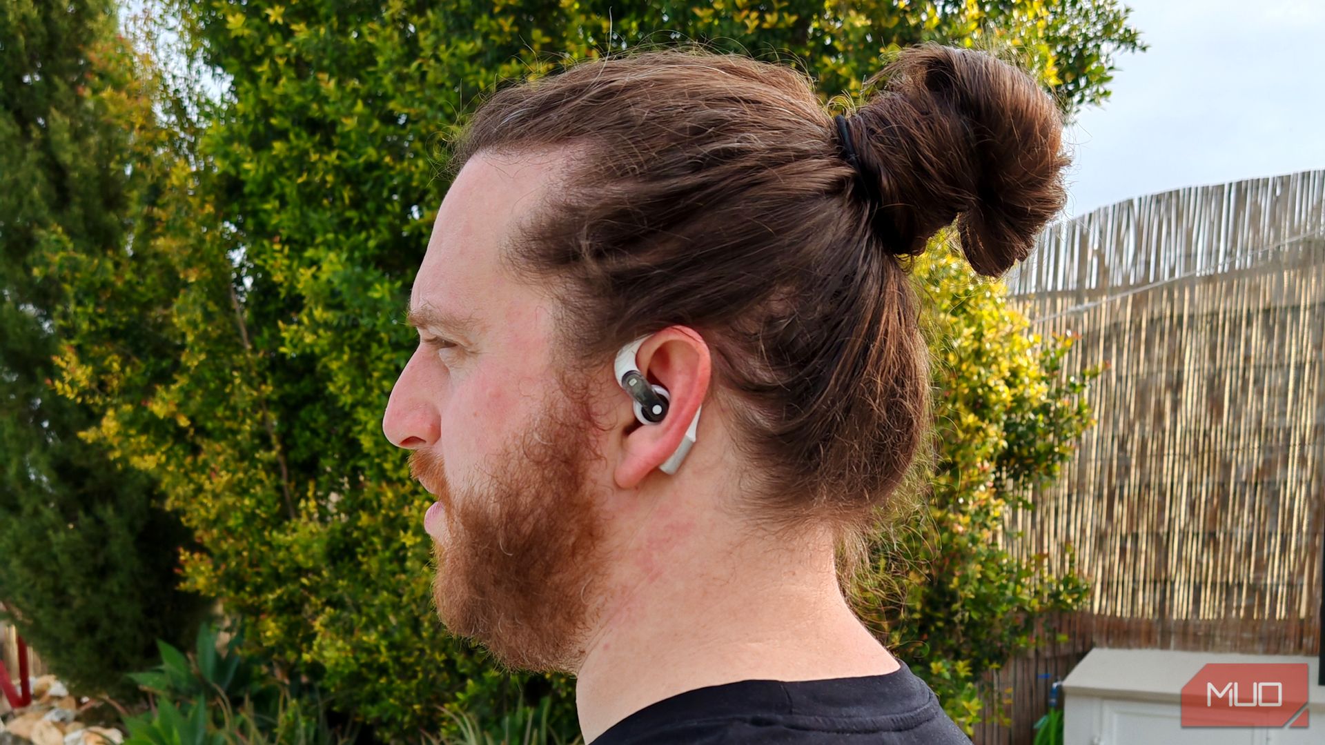 man wearing nothing ear open earbuds left side view.