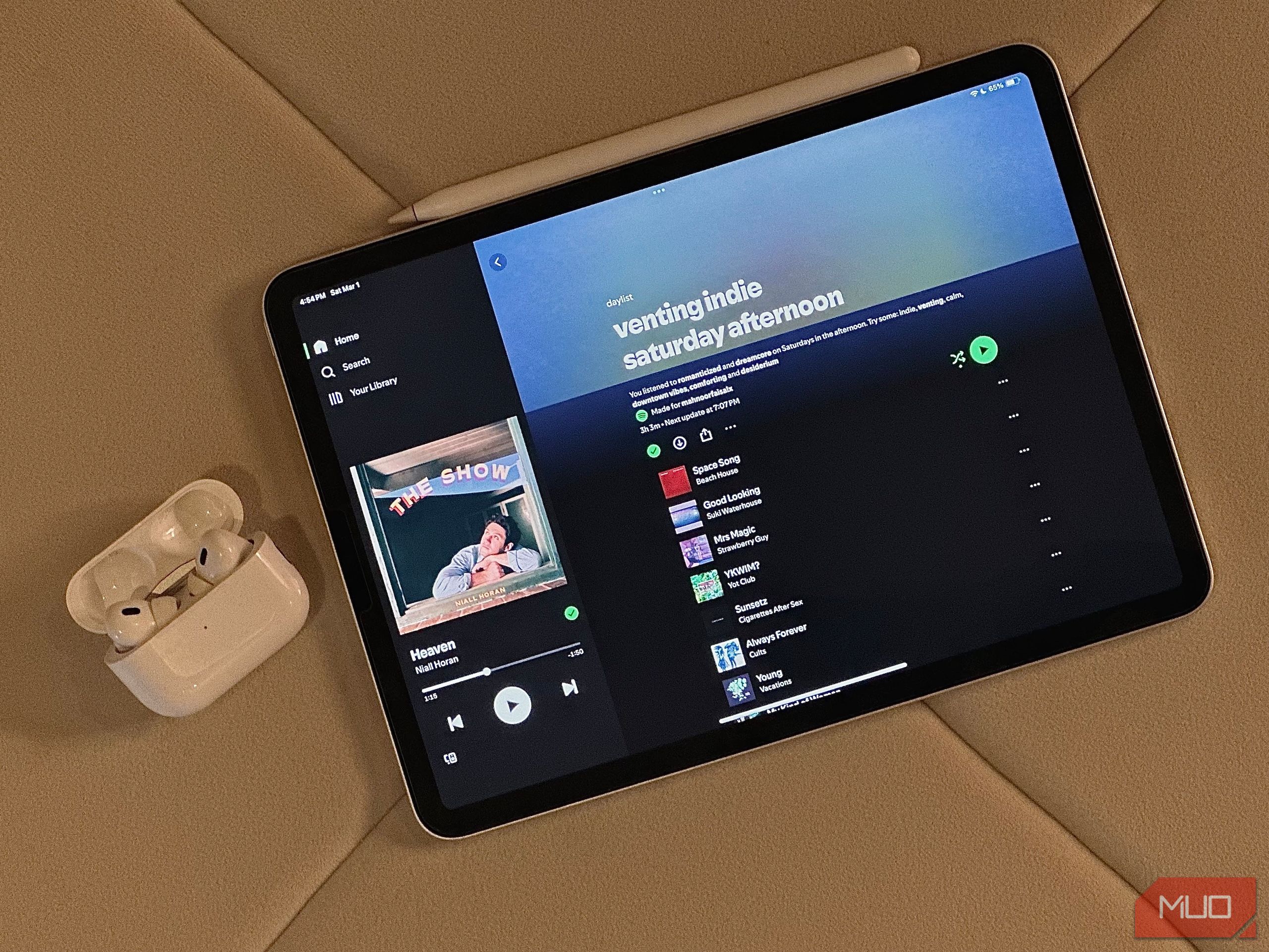 Daylist on an iPad alongside Airpods case