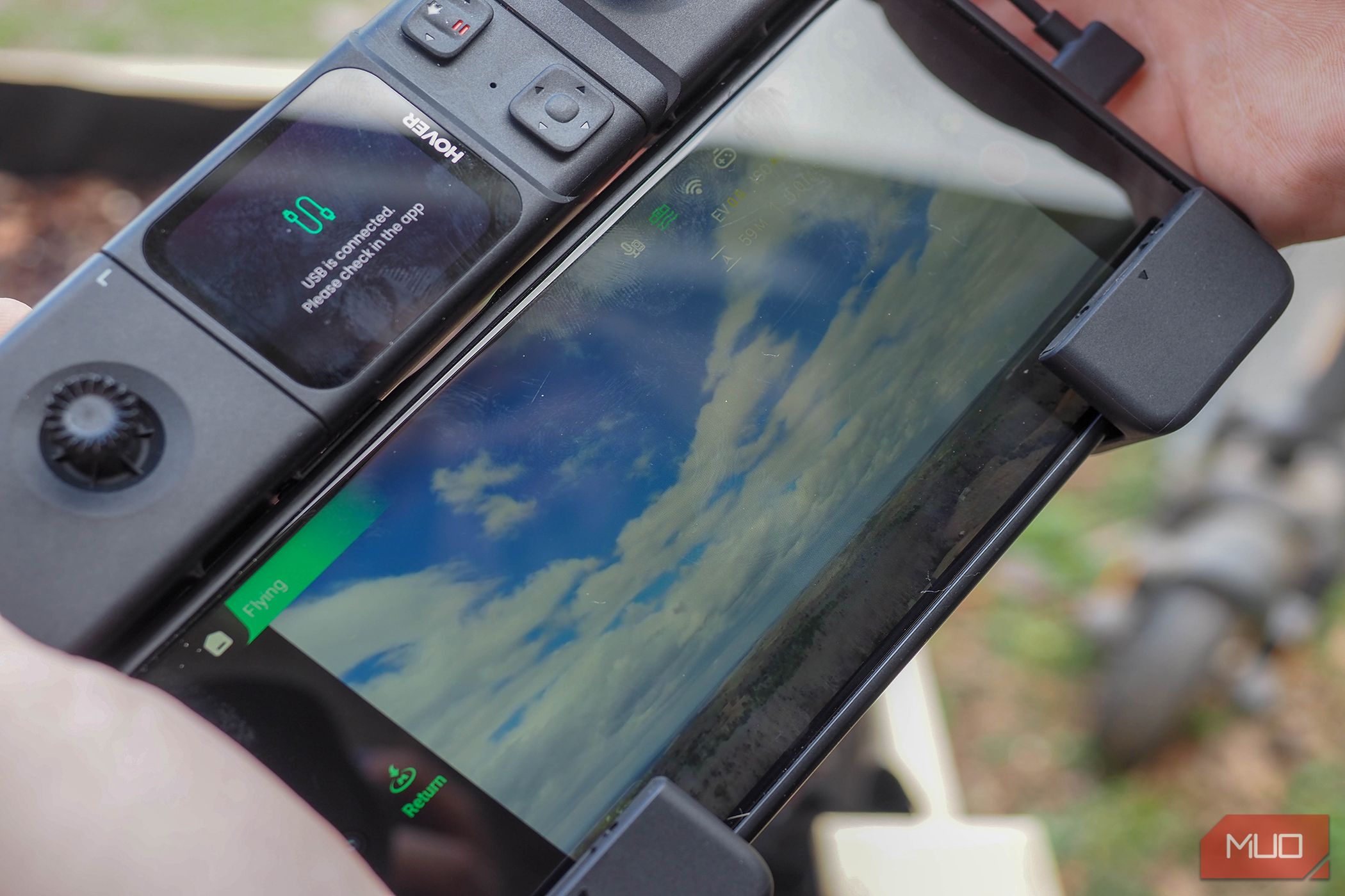 HoverAIR x1 Promax phone attached to beacon and remote control sticks.