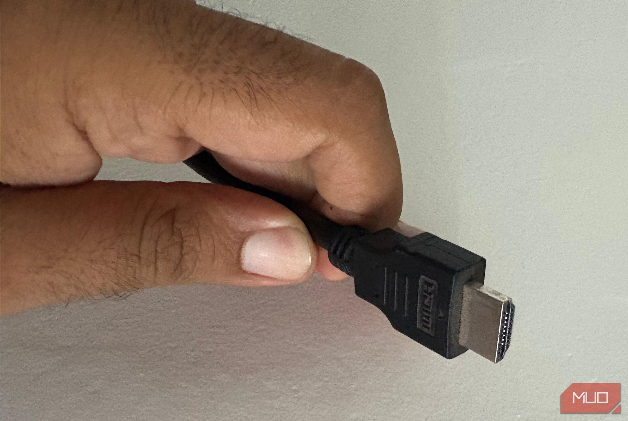 An image of a man holding an HDMI cable