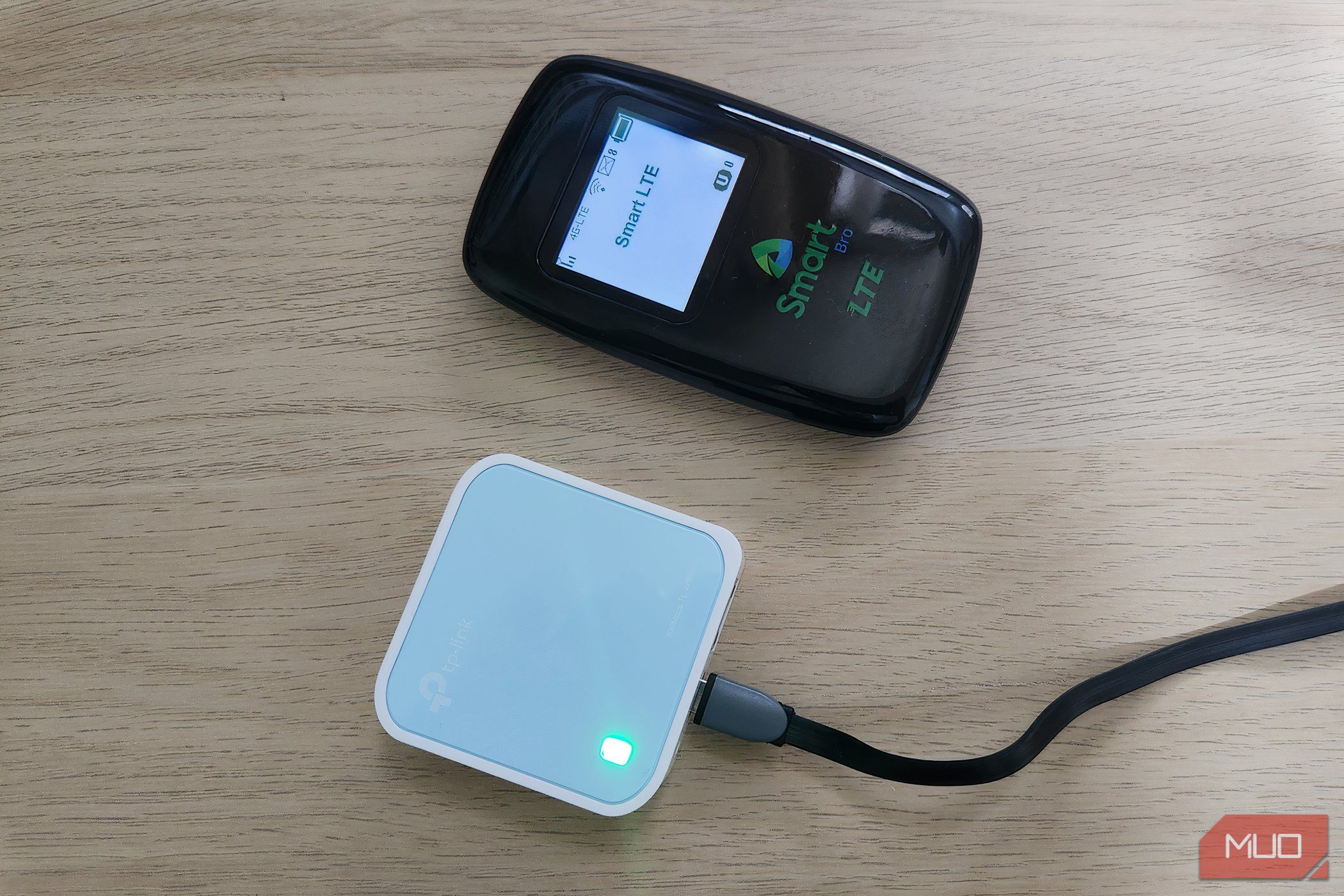 A mobile hotspot and travel router on a desktop.