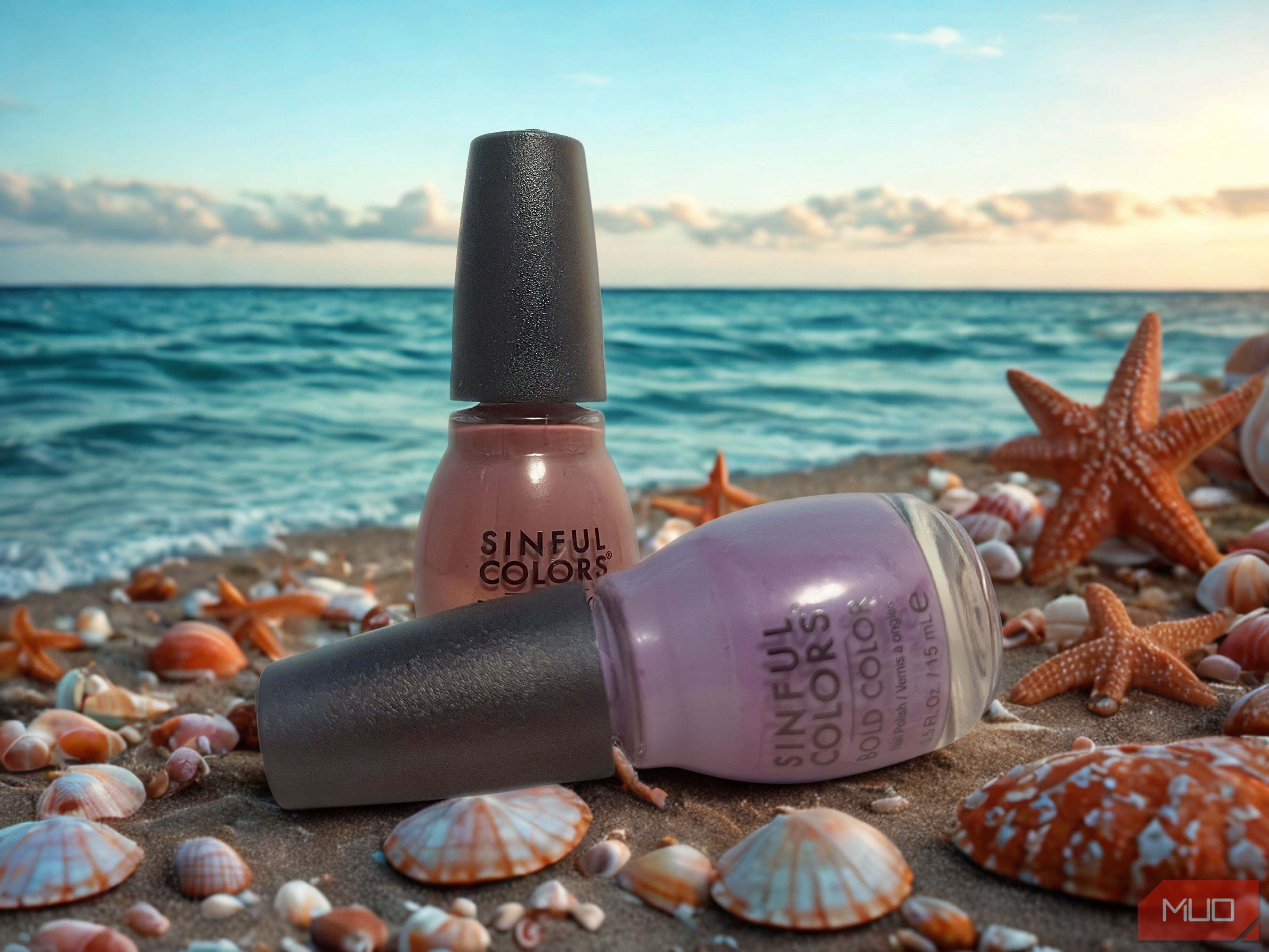 Nail polish bottles on a beach with shells and starfish