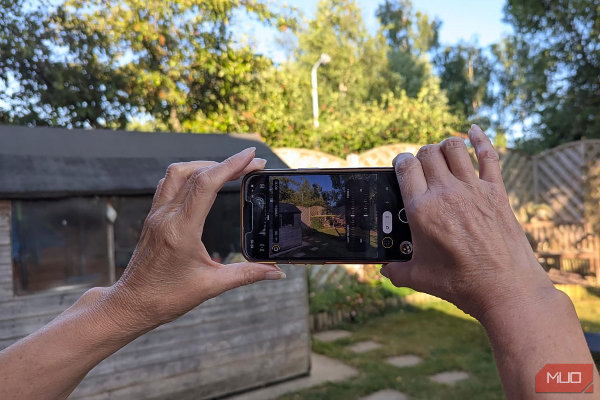 Hands holding an iPhone horizontally with the Project Indigo camera on the screen