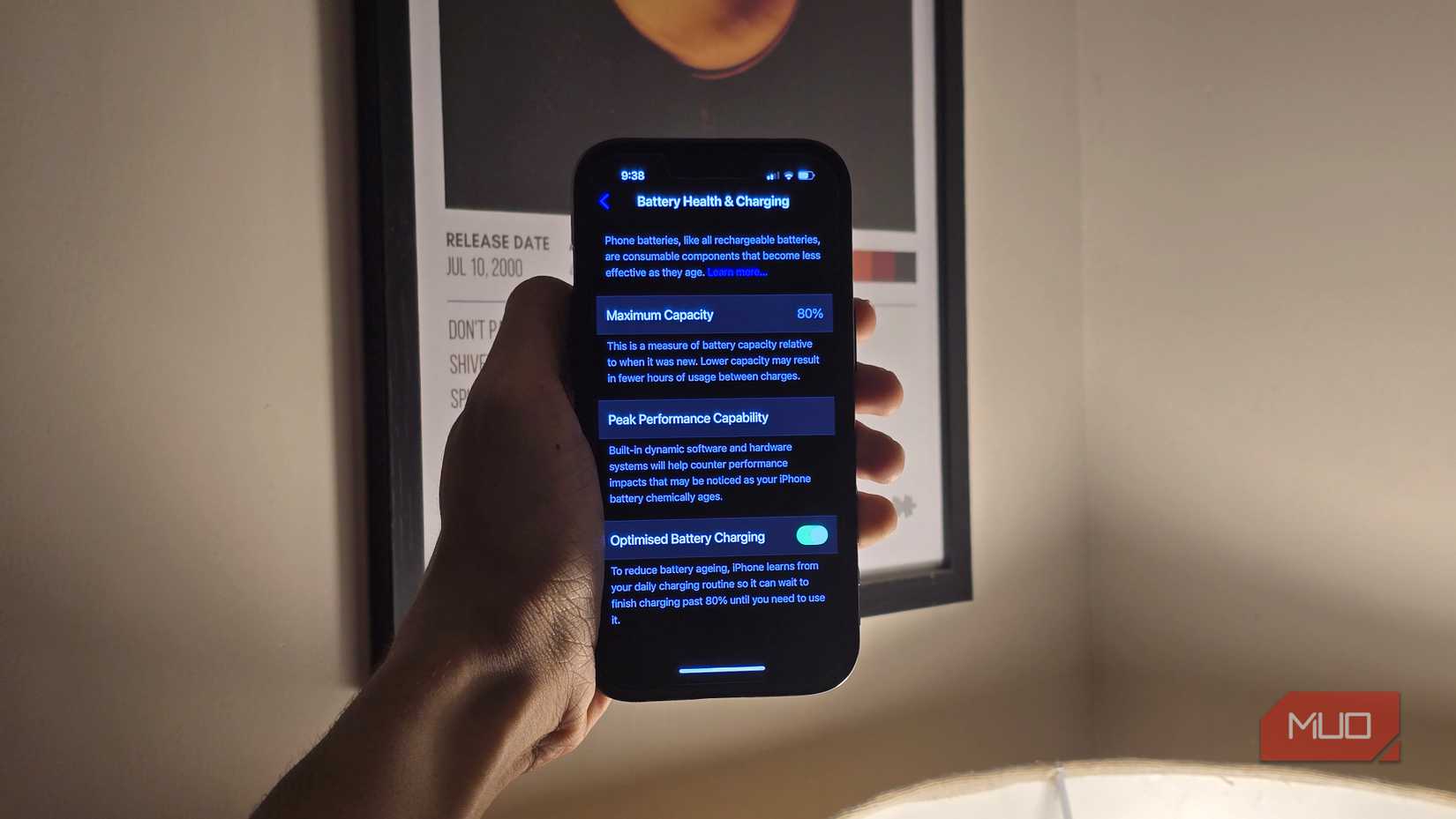 Person holding an iPhone with the Battery Health & Charging menu open