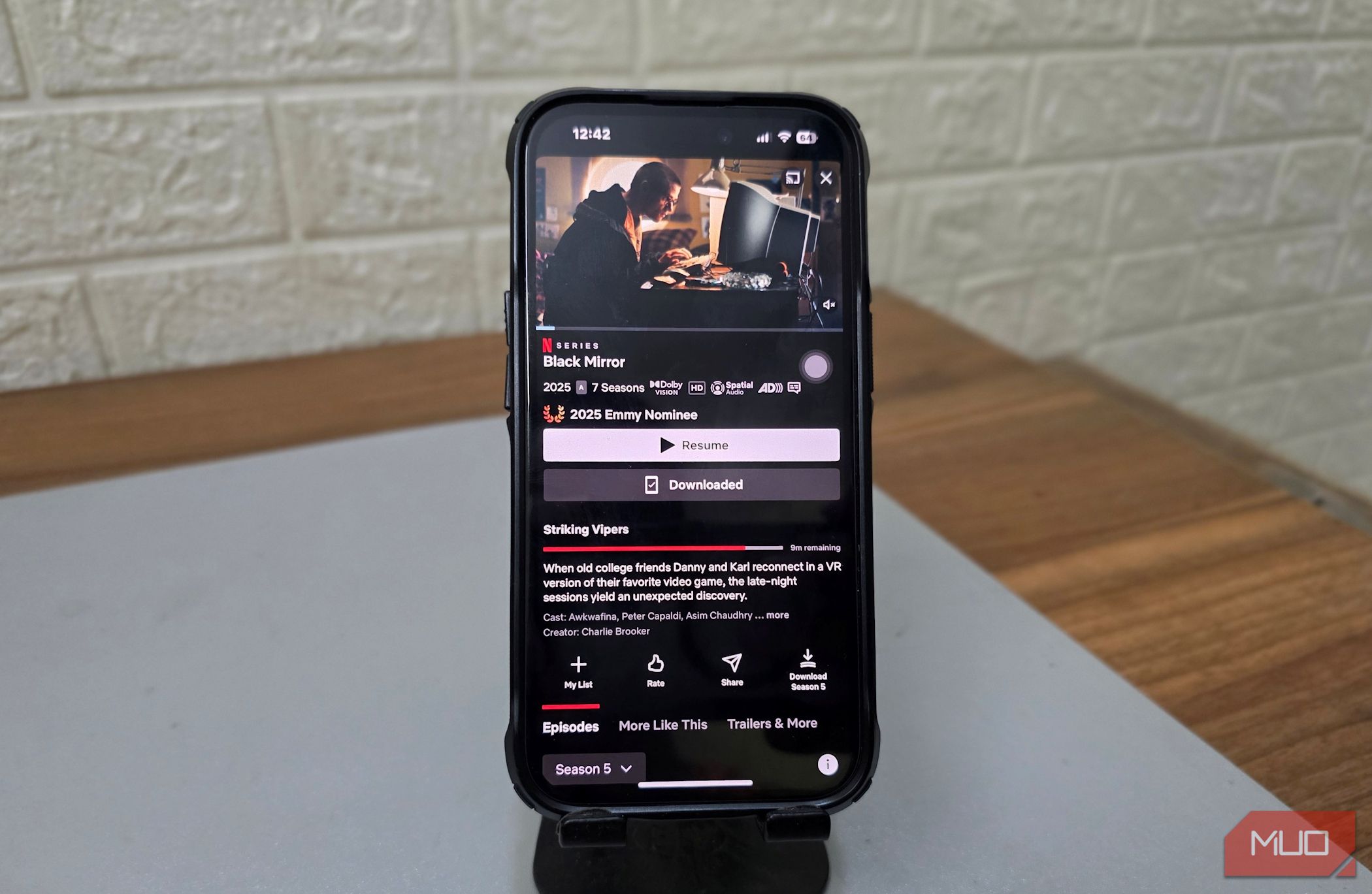 A phone holder holds an iPhone with Netflix open