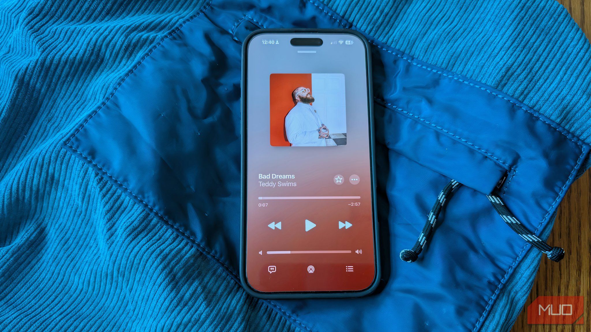An iPhone with Apple Music playing on a table.