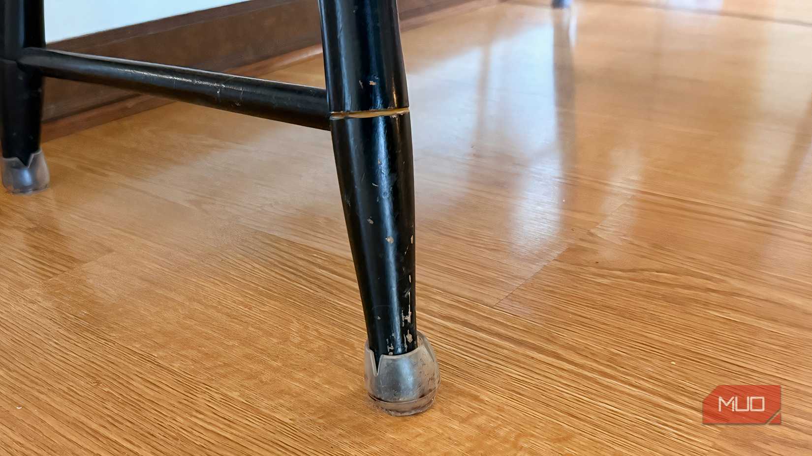 A laminated floor being shown under a table in a kitchen. 