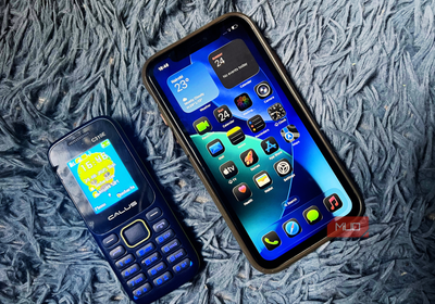 iPhone 11 and a feature phone placed on a blue background