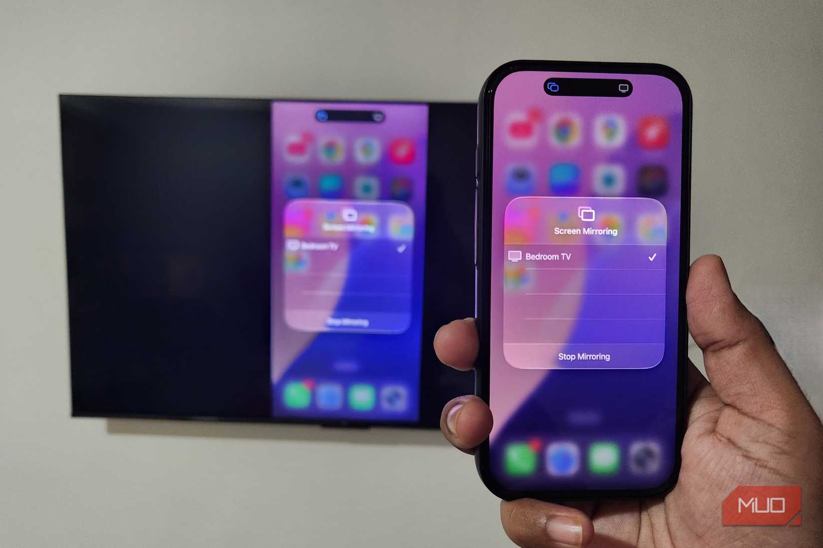 iPhone in hand mirroring screen to TV