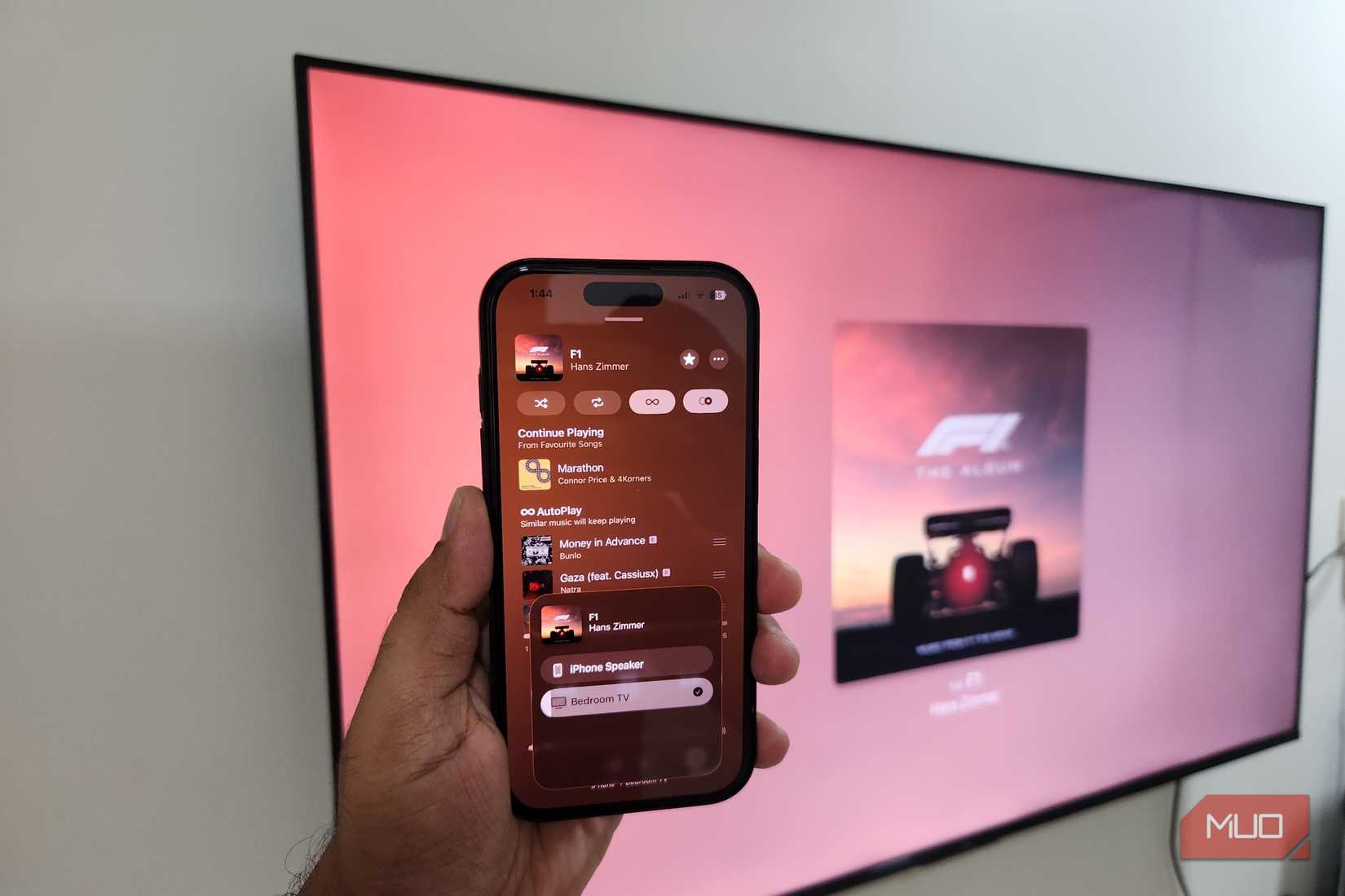 iPhone in hand playing song on Google TV using AirPlay