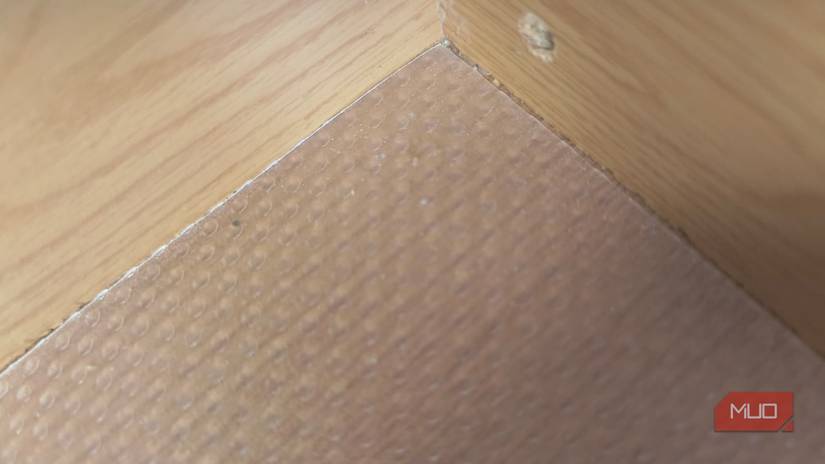 The corner of a drawer with plastic liner in the bottom