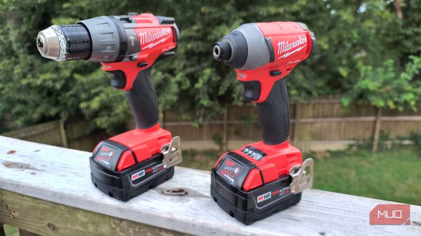 A cordless drill and driver on a wooden rail