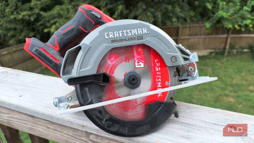 A circular saw sitting on a wooden rail