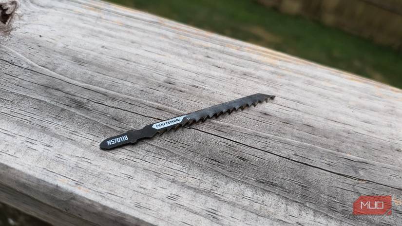 A jigsaw blade sitting on a wooden rail