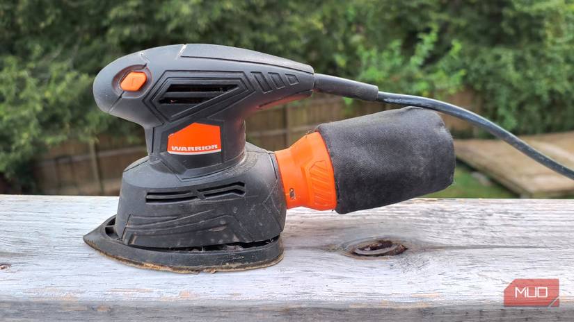 A small electric sander on a wooden rail