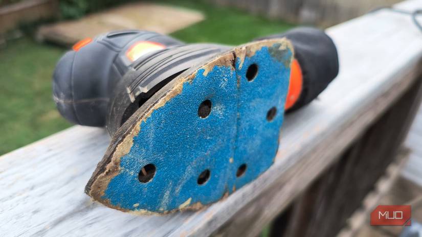 The bottom of a small electric sander on a wooden rail