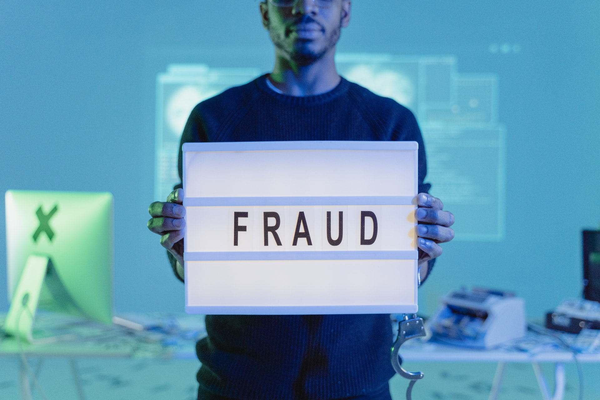 So schützen Sie sich vor betrügerischen Geschäften bei Shopify - man holding laptop says fraud
