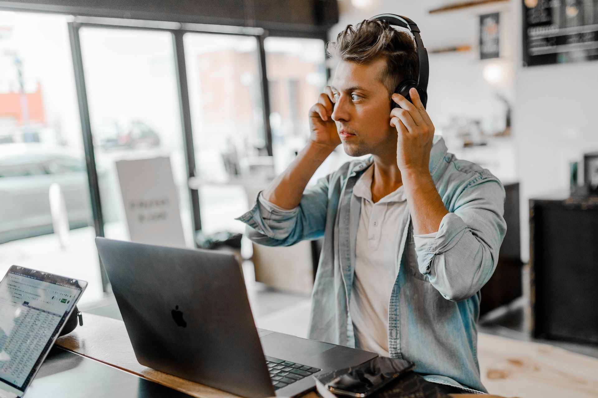 man weating headphones using laptop - 13 Lavori in Smart Working per i quali puoi essere assunto oggi