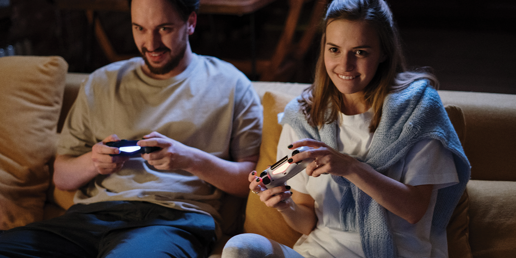 couple playing games on the sofa - Come i videogiochi possono avvicinare le coppie
