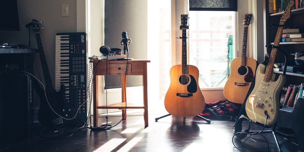 guitars next to microphone and headphones on table - Come registrare la tua chitarra acustica ed elettroacustica: 3 ottimi metodi